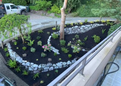 Winding attacked stone retaining walls with plantings and dark fine mulch