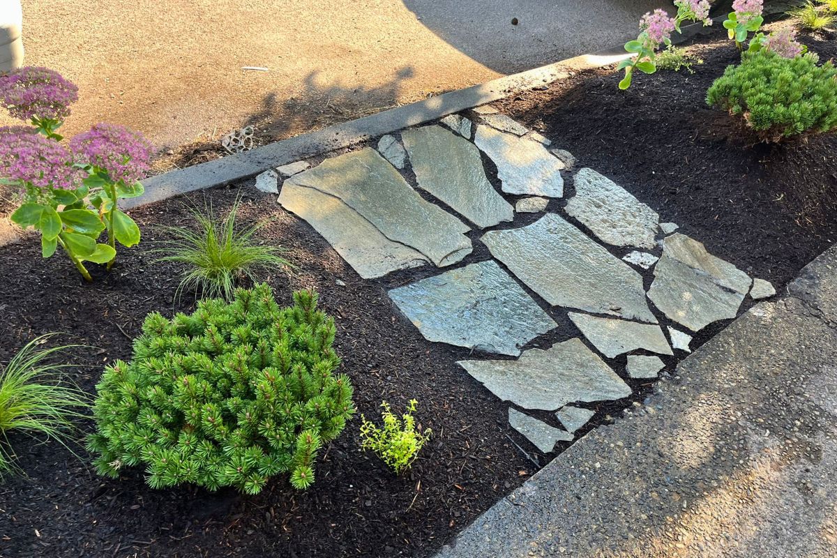 Permeable paver pathway replacing worn grass path.