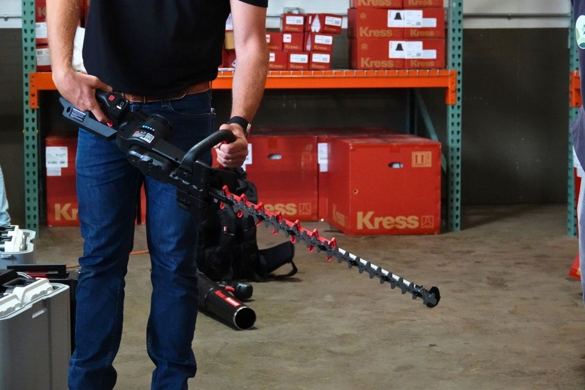 Professional landscaper using an electric hedge trimmer in a Seattle 