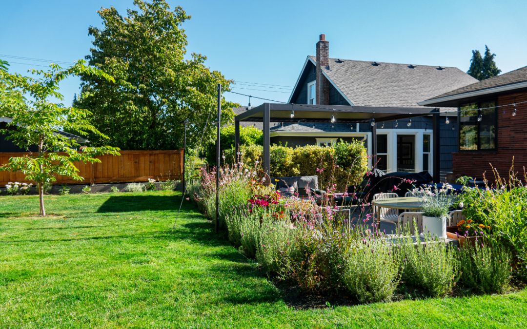 Outdoor covered patio next to seasonal plantings and a fresh green lawn recovered from drought